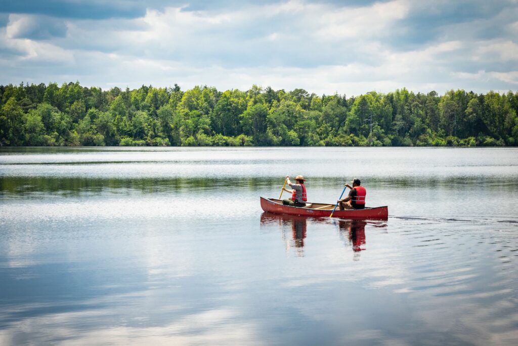 Two men canoeing in the middle of a lake.